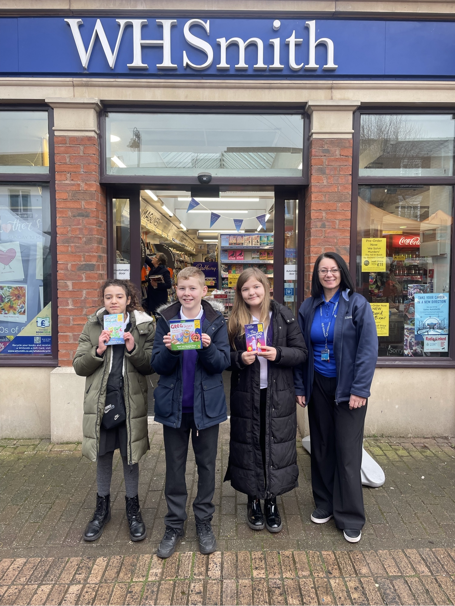 Broughton Primary School Reading Champions at the Mold WH Smith store with staff member Joanne Latham.