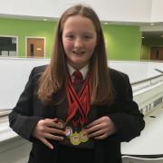 Ysgol Treffynnon student, Ellen Davies, with her haul of swimming medals.