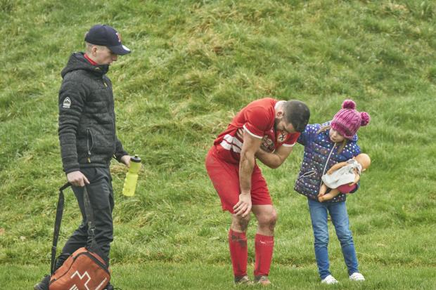 Six year old Lucy Gittins comforts Rhayader Town footballer Tony Davies after his injury on Saturday. Picture by Ian Francis.