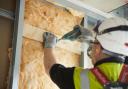 A builder installing insulation