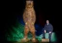 Talented chainsaw sculptor Paul Morris from the Pendine Park gardening and maintenance team with his latest masterpiece, the giant grizzly bear