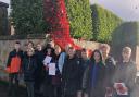 Children with the poppy waterfall at the Cefn Mawr Cenotaph.