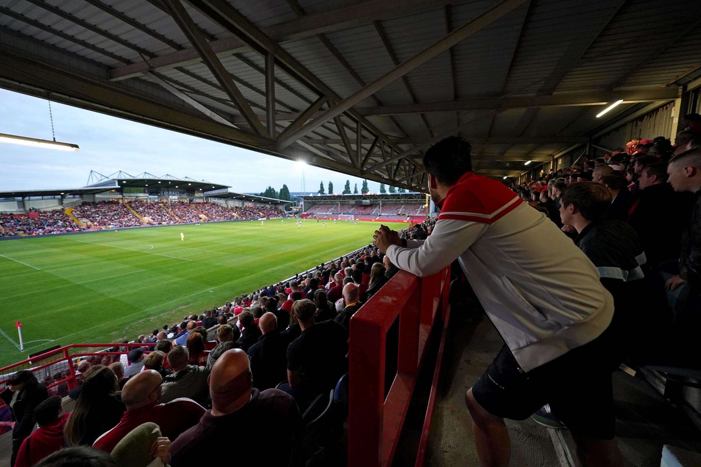 Wrexham fans watch the game from the stands during the Vanarama National League match at The Racecourse Ground, Wrexham. Picture date: Monday August 30, 2021.