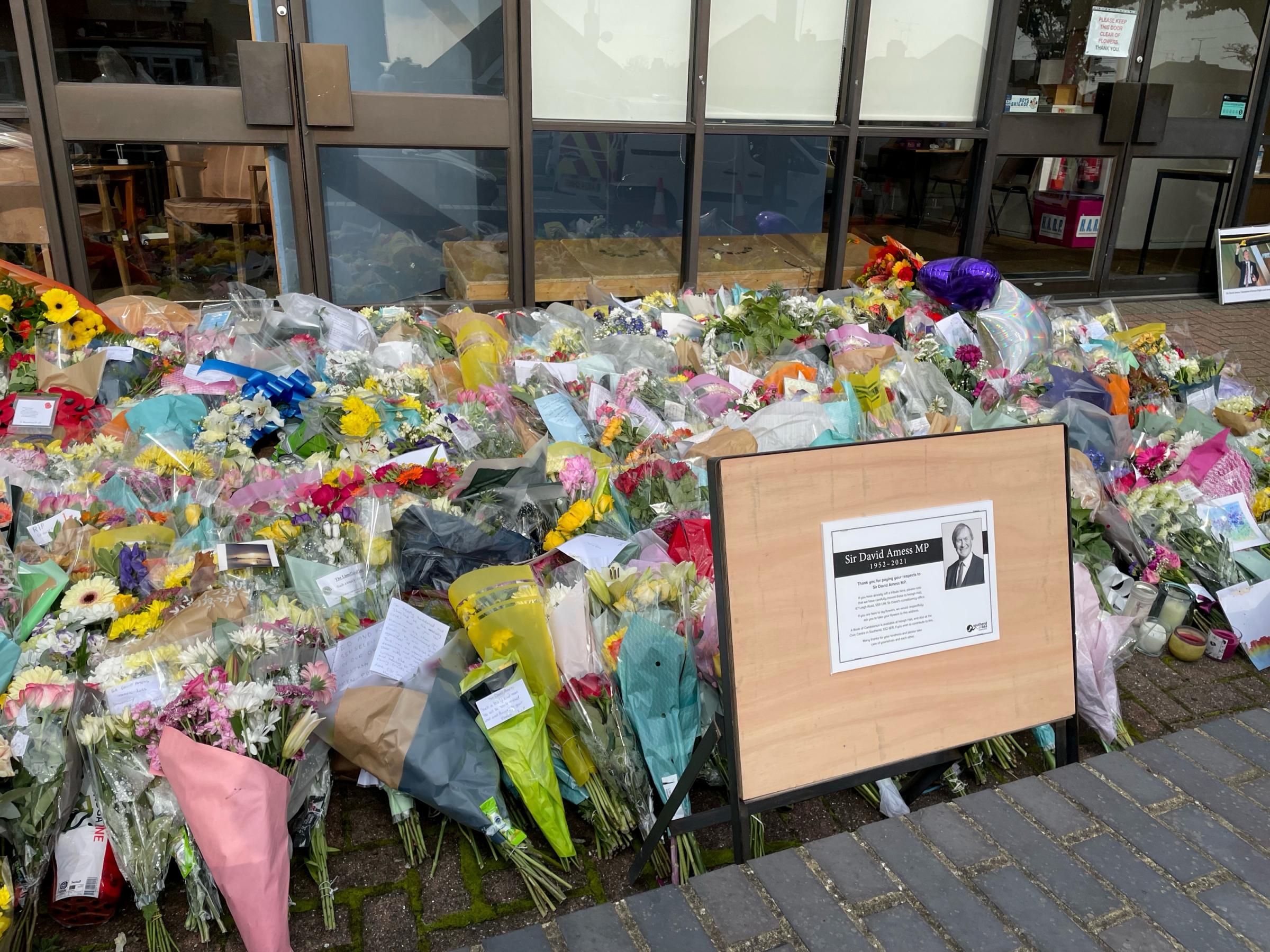 A sign placed next to the floral tributes left outside the Belfairs Methodist Church in Leigh-on-Sea, Essex, where Conservative MP Sir David Amess was killed on Friday. Picture date: Tuesday October 19, 2021.