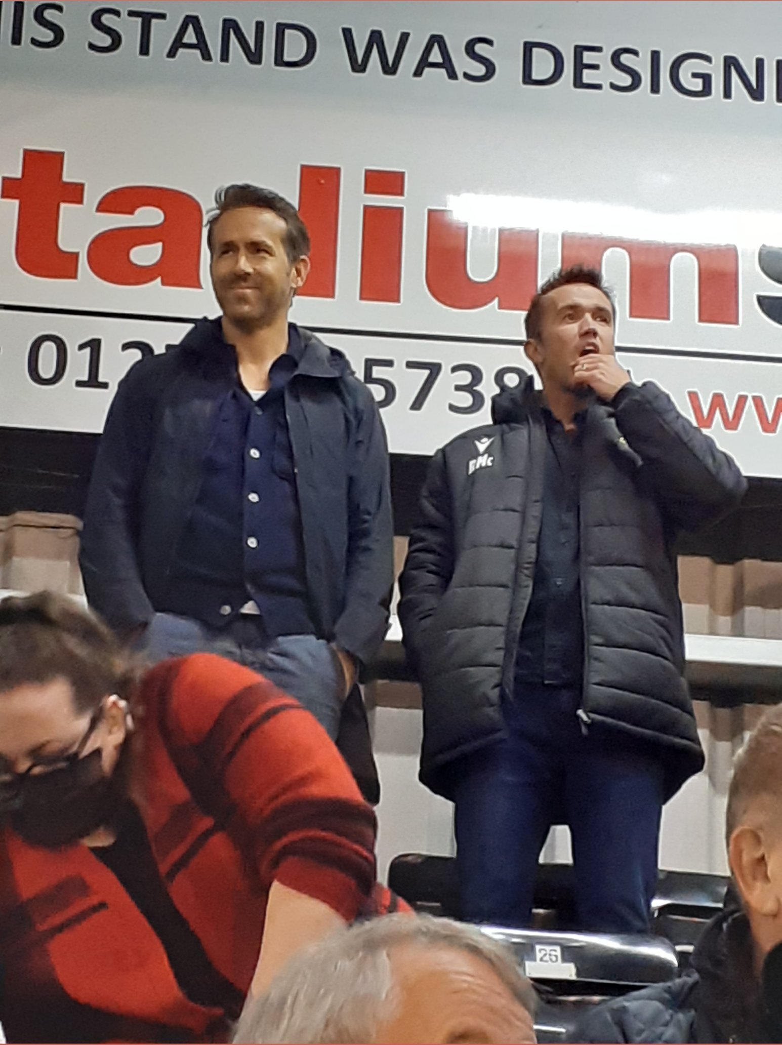Handout photo taken with permission from the twitter feed of @tristanswalk showing Wrexham AFC owners Ryan Reynolds (left) and Rob McElhenney during the Vanarama National League game at York Road, Maidenhead. Picture date: Tuesday October 26, 2021.