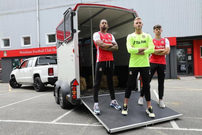 Wrexham players Jamie Reckord, goalkeeper Rob Lainton and Jordan Davies emerging from the Ifor Williams Trailers HBX horsebox.