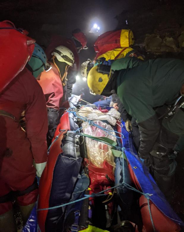 The Leader: Handout photo taken with permission from the Facebook page of the South & Mid Wales Cave Rescue Team of members of a rescue team carrying an injured caver on a stretcher through a cave. (PA)
