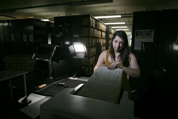 The Leader: Photo via PA shows Findmypast technician Laura Gowing scans individual pages of the 30,000 volumes of the 1921 Census at the Office for National Statistics (ONS) near Southampton.