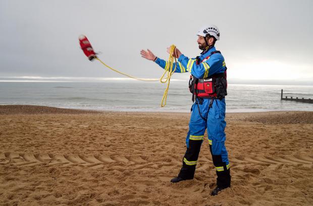 The Leader: HM Coastguard Coastal Operations Area Commander Tom Wright casts a throwline on Southbourne beach in Dorset (PA)