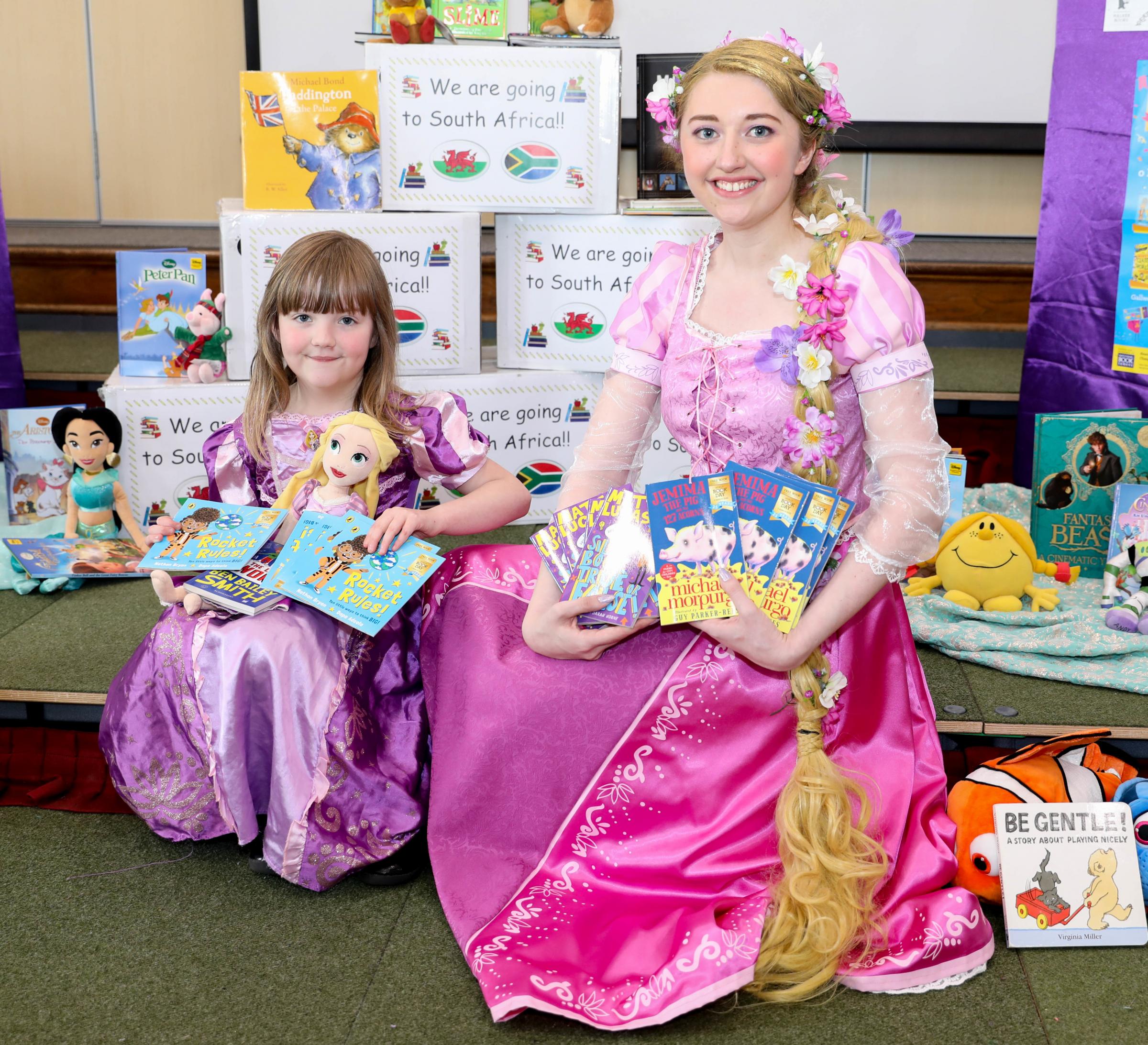 Teacher Anna Lyndsay with Holly Ecob, pictured in costume for World Book Day, with some of the books collected for a school in Africa.