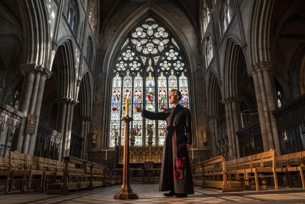The Leader: Very Reverend John Dobson Dean of Ripon lights a candle to mark the second anniversary of the first national coronavirus lockdown at Ripon Cathedral, North Yorkshire, ahead of the National Day of Reflection on Wednesday (PA)