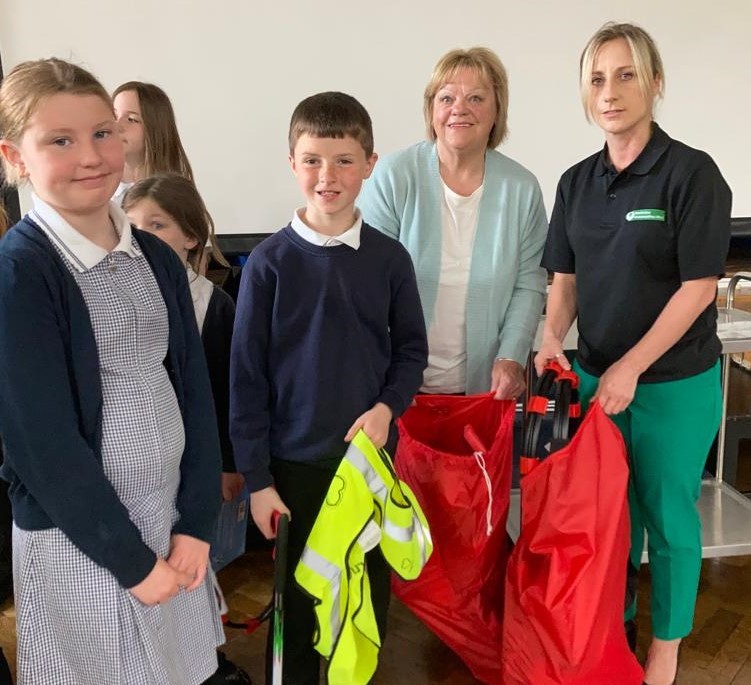 Ysgol Bryn Devan Eco Council receive their litter picking sacks from Vivien Corbett-Jones of the Deeside Litter Picking Group and environment officer from Flintshire County Council Mrs Adrianna Szostakowska.