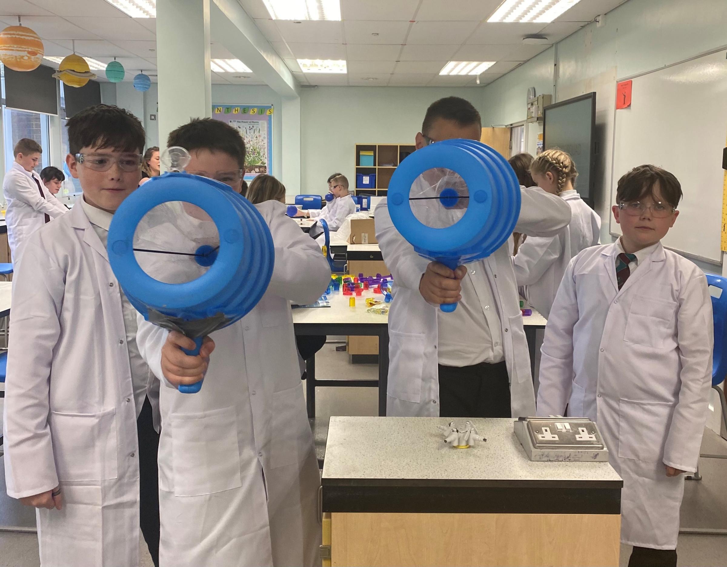 A group of boys investigate the movement of particles using Air Zookas. 