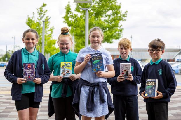 Students holding their new books from a Young Reader’s Programme event at Broughton Shopping Park.