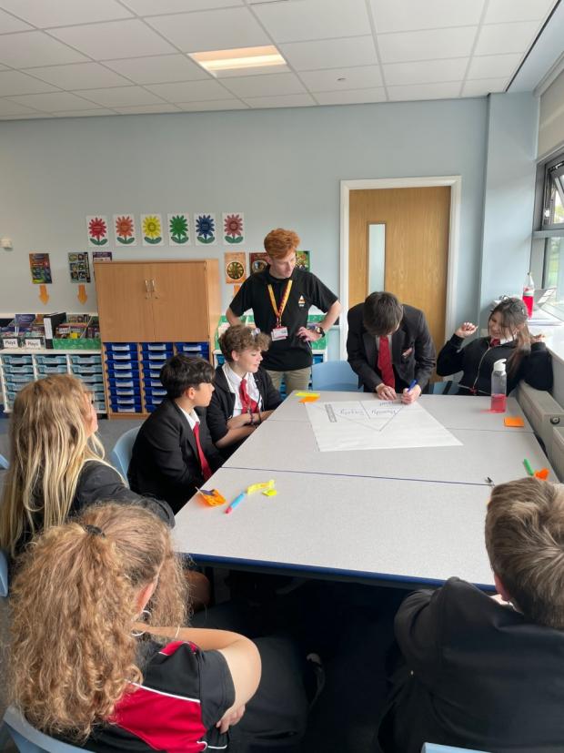 The Leader: Owain observes the students' thoughts as they are written in the triangle.