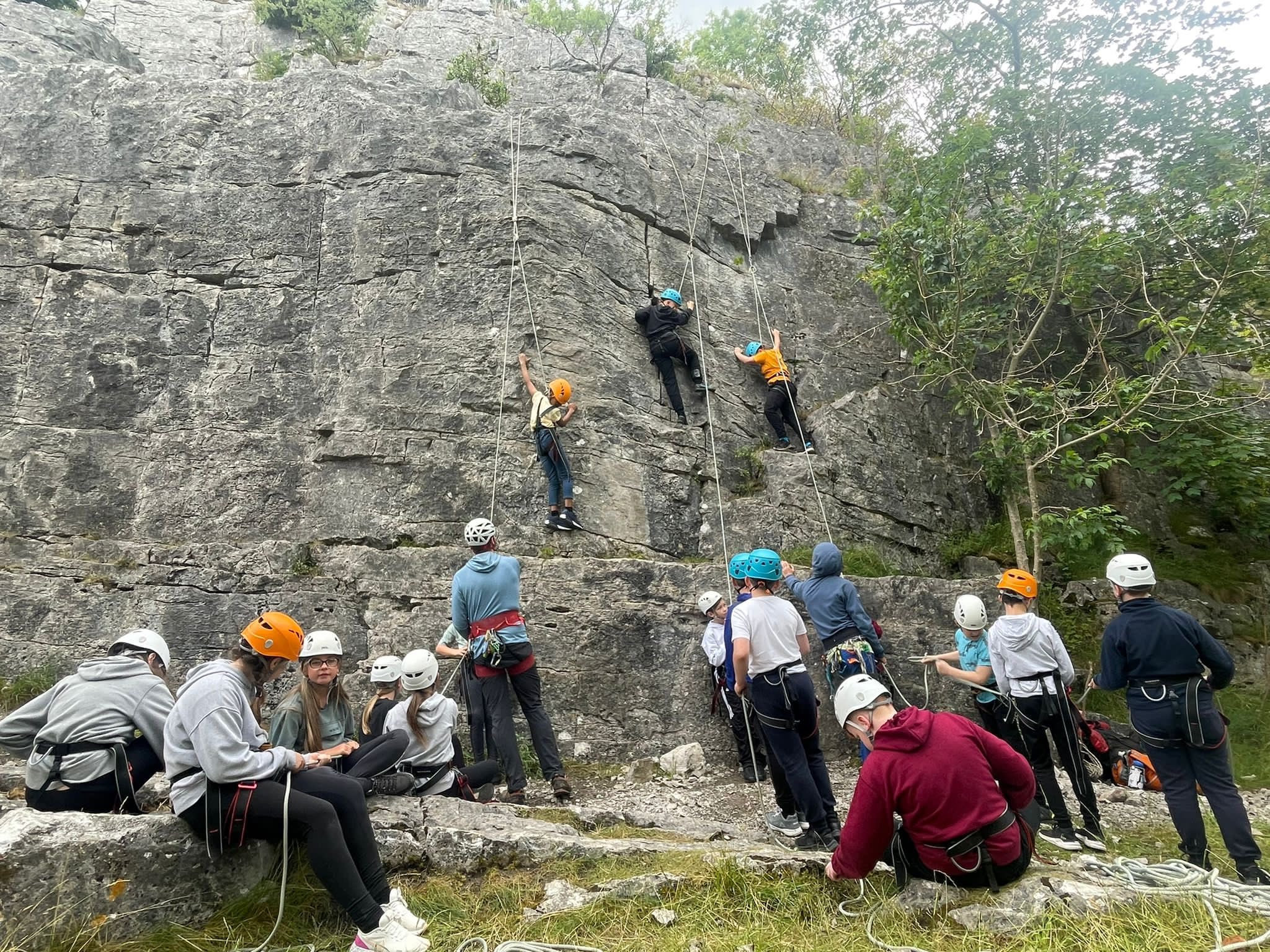 Students take turns to scale the rocks.