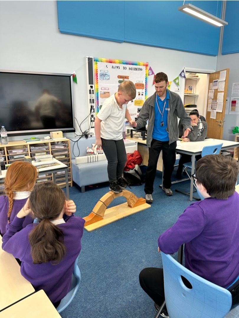 Pupils learn about bridge construction with staff from Xplore! and test the strength.