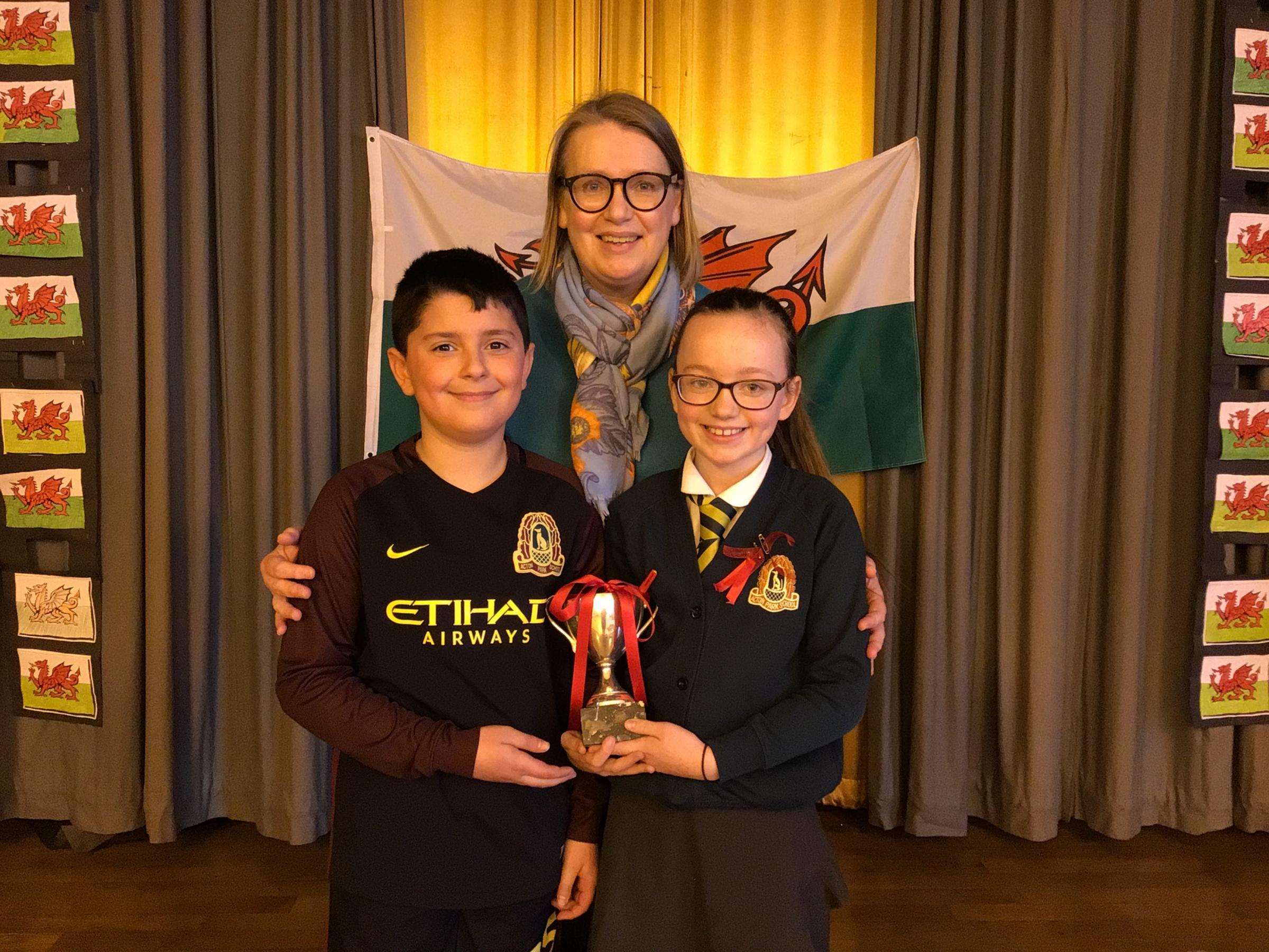 Dyfrdwy house captains Mihaile Tinaise and Peyton Grace Price, receiving the cup from headteacher Jo Grundy.