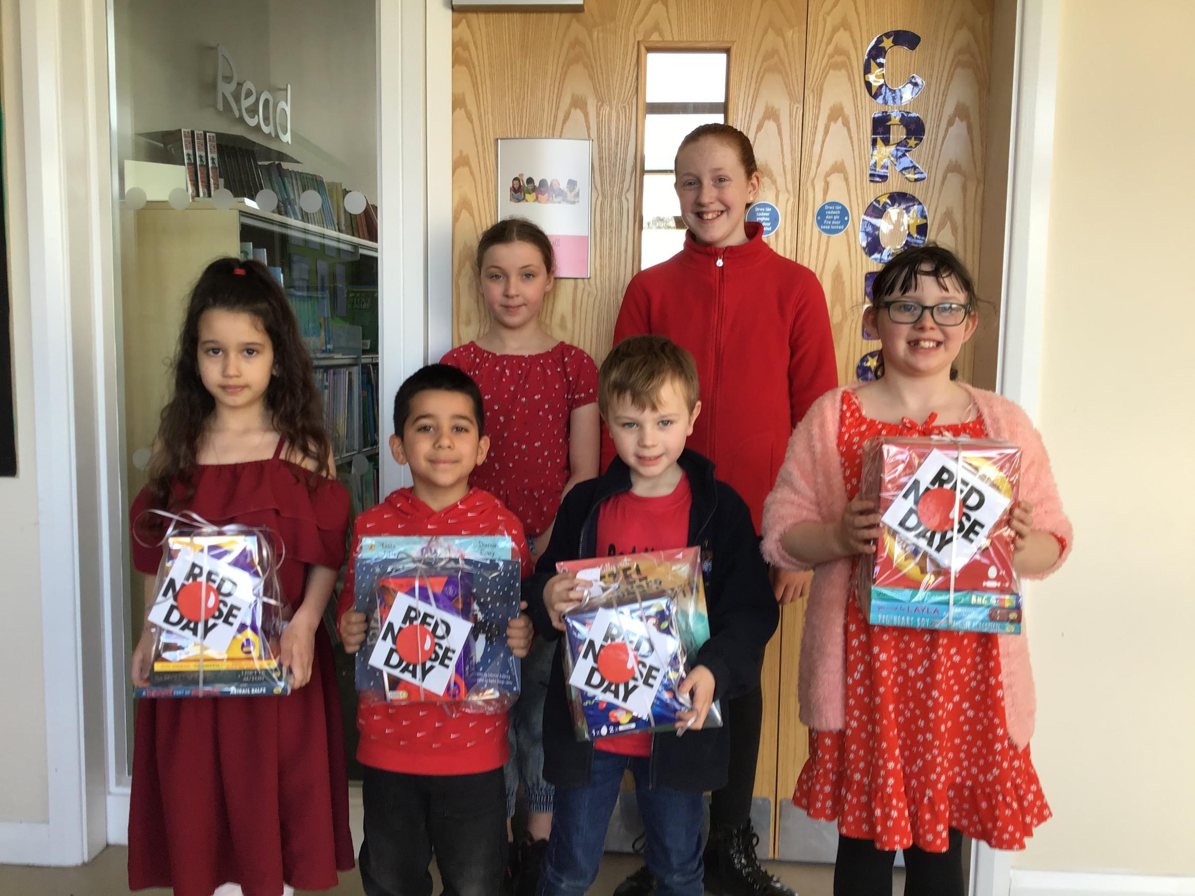 School councillors Ava and Evie, who presented prizes Red Nose Day winners Seren, Logan, Rowan and Adelina.