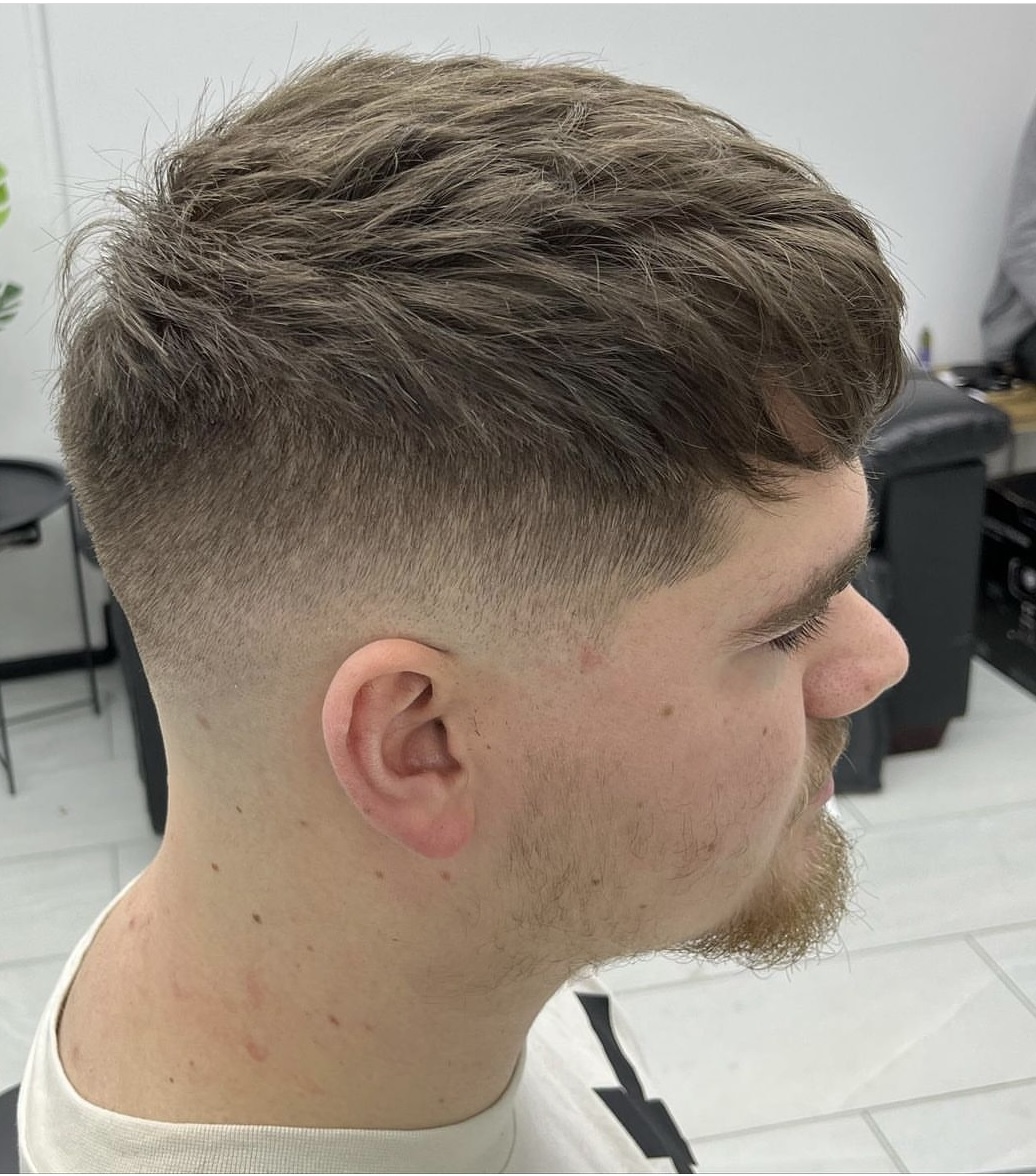 Skin fade with heavy texture on top, done by Ned.