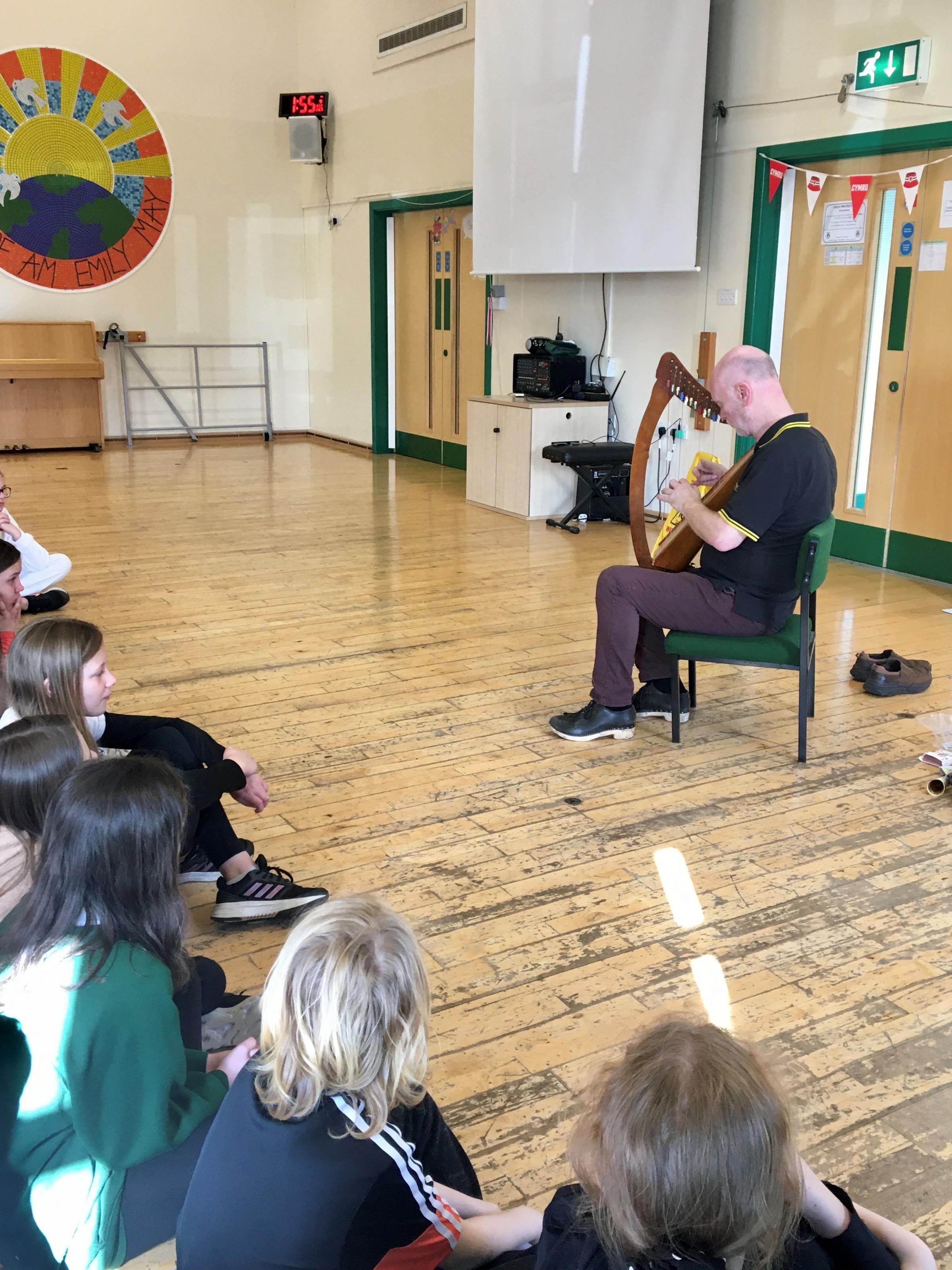 Huw Williams from Upbeat Music and Arts entertains children at Ysgol Penygelli.