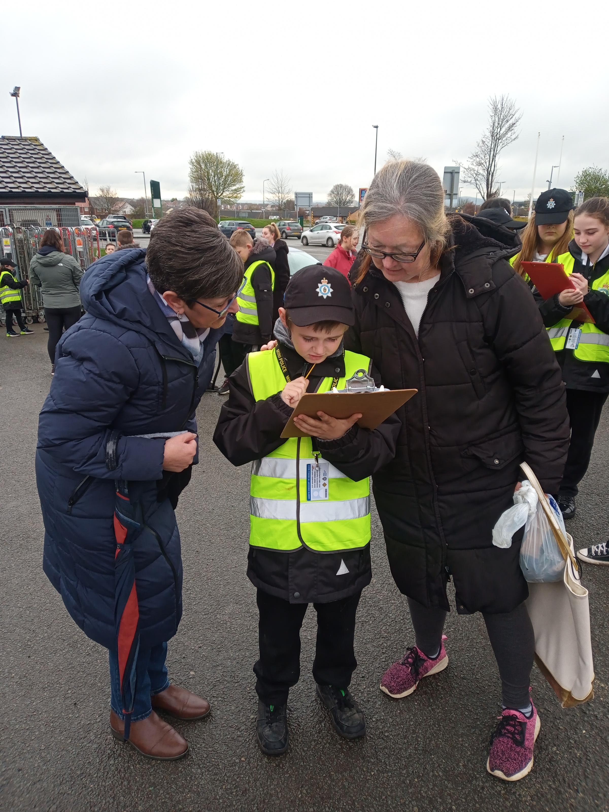 Staff member Kathy Webster and Mini Police member Mikey, interview resident Diana Payne for their survey.