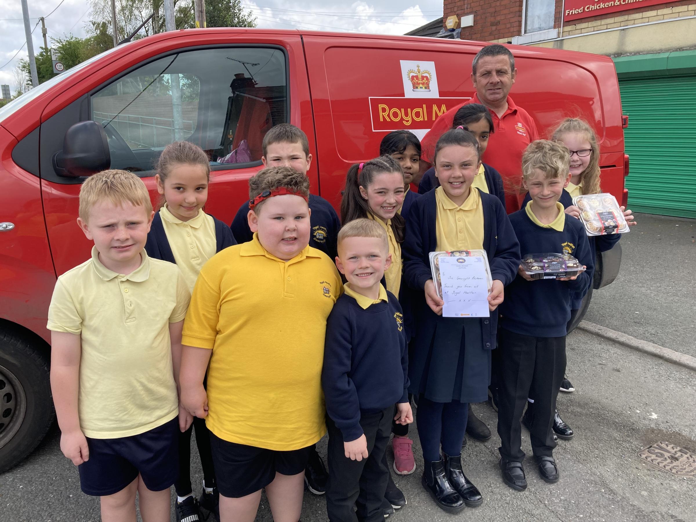 Ysgol Heulfan pupils deliver cakes to the posties of Gwersyllt.
