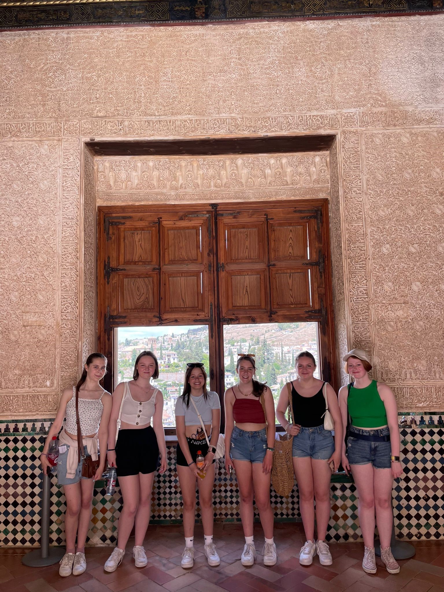 Antiguos alumnos de secundaria con el Palacio de la Alhambra al fondo.