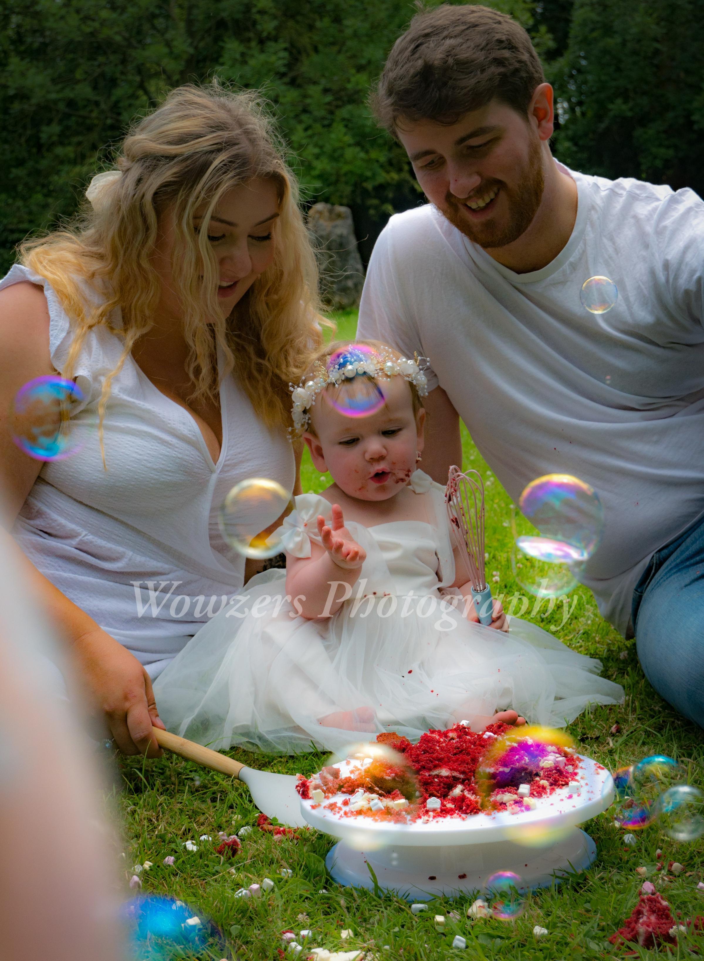 Family photo with baby Alyssa and her parents Zoe and Chris Curtis, her first birthday cake smash photoshoot, at Acton Park, Wrexham. 