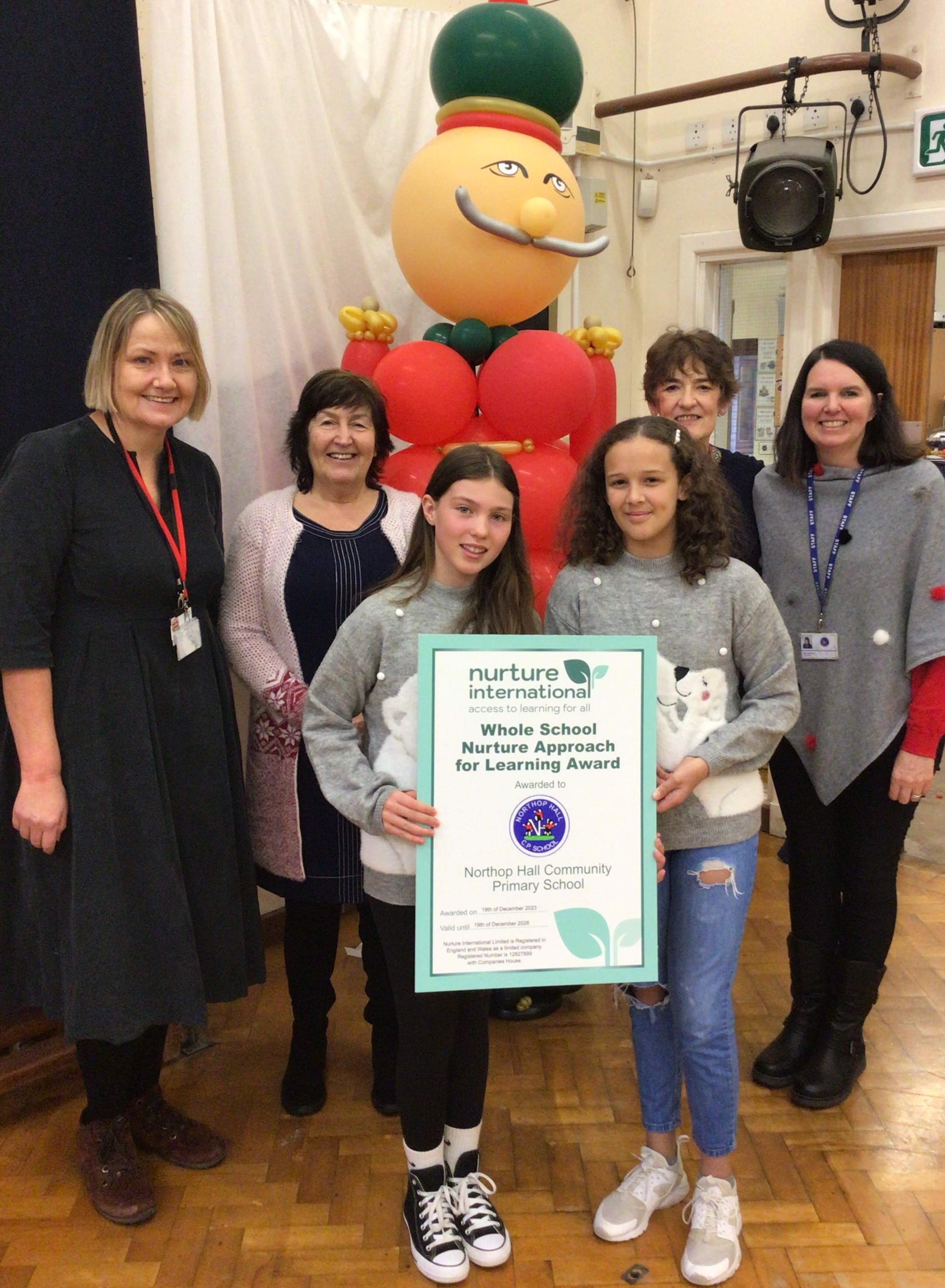 Linda Callaghan (local authority), Yvonne Monaghan and Alison Grimshaw (Nurture International) and Lynne Harrison (headteacher) with Year 6 pupils, receiving the certificate.