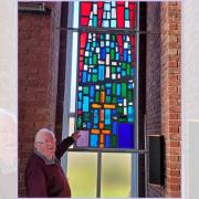 Mike Bunting with one of the newly installed stained glass window.