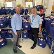 David Roberts, left, of Harlech Foodservice with Newydd Business Operations Manager Rob Lawton with the food bags ready for Flintshire schools