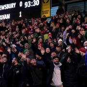 Wrexham fans celebrate their victory away at Shrewsbury Town's Croud Meadow ground.